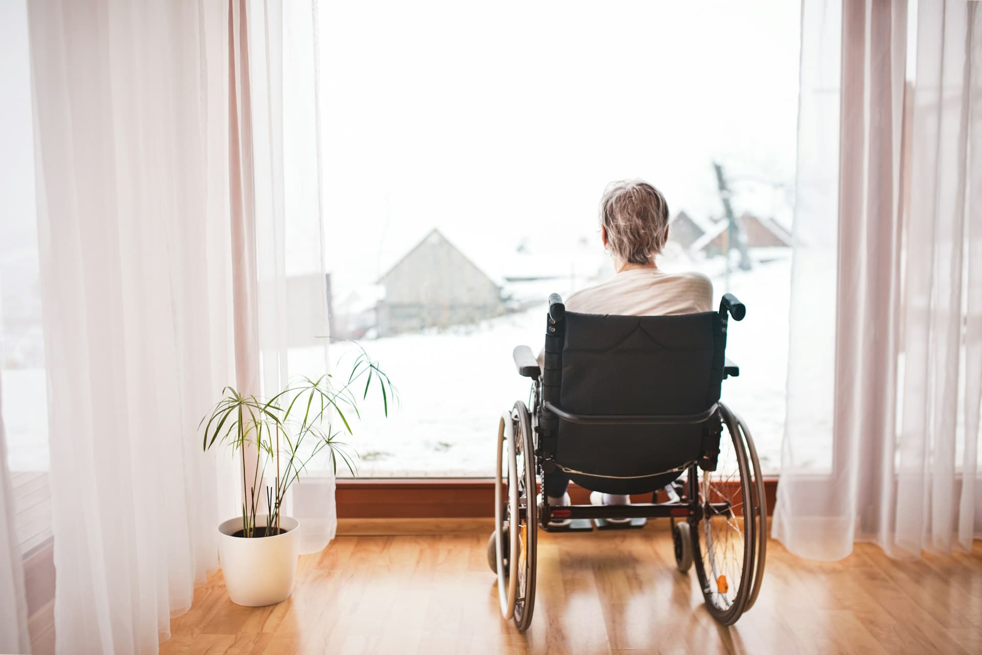 a person in a wheelchair looking out a window